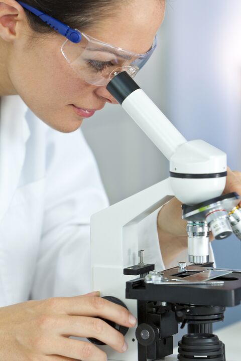 Une femme regarde au microscope